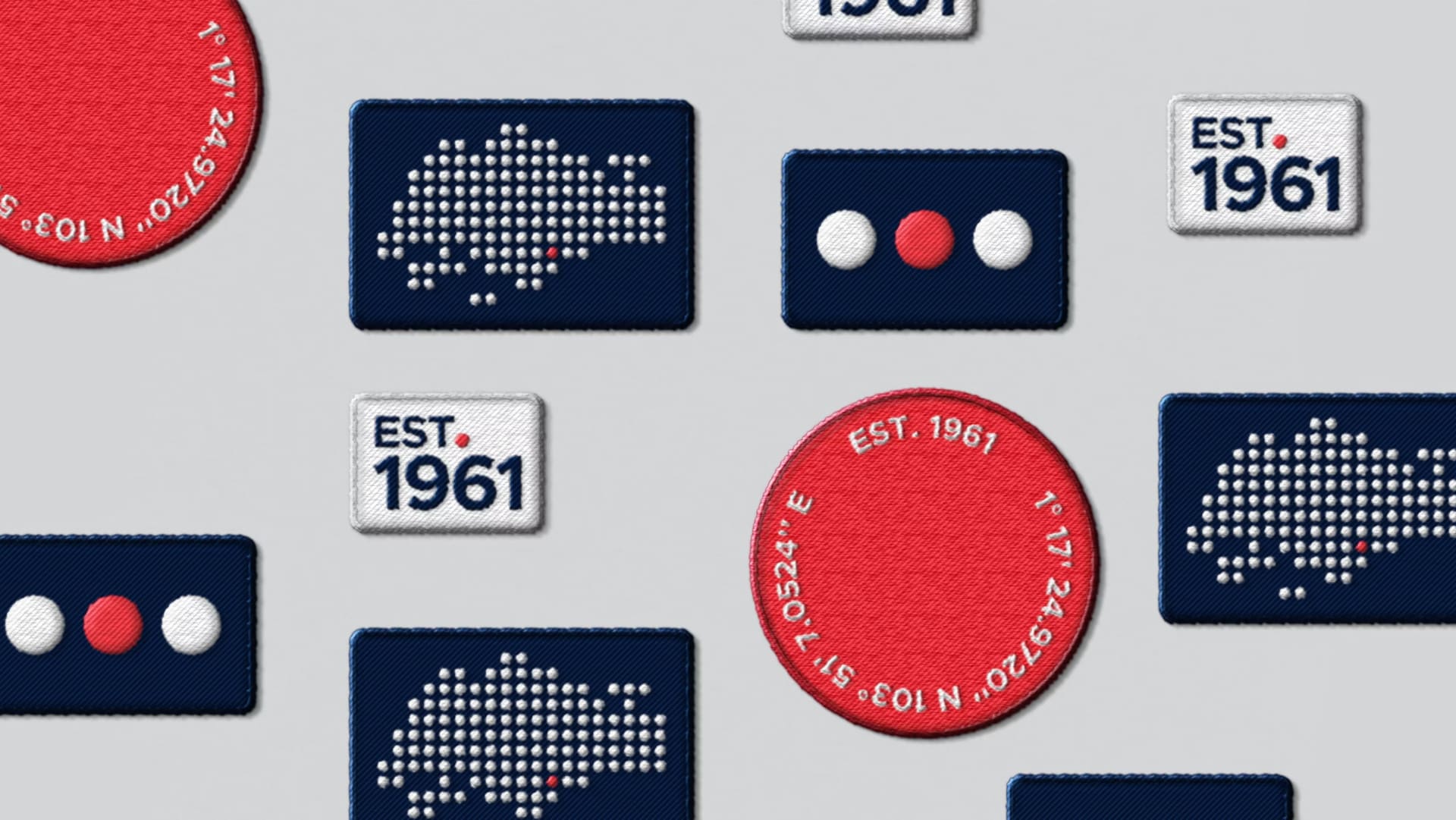 EDB badges and stickers: “Est. 1961” labels, a red coordinates seal and dotted Singapore maps