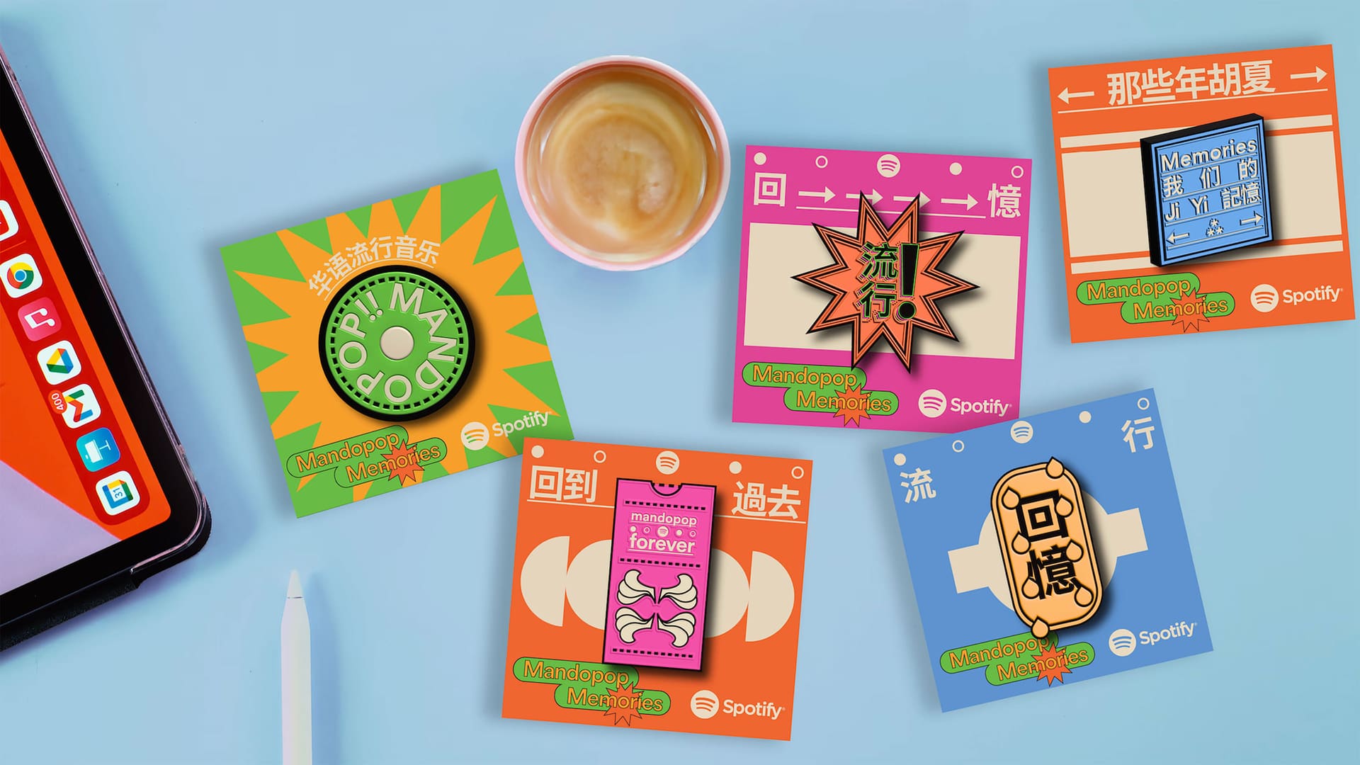 Mandopop Memories enamel pin cards beside a coffee and a tablet